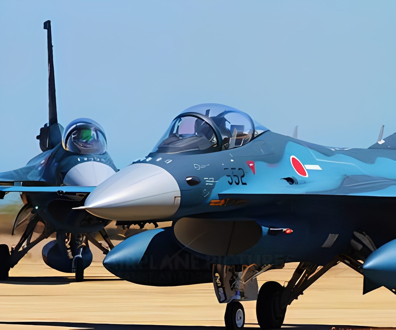 Military jets on an airfield runway.